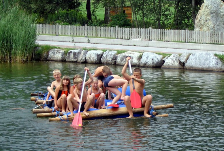 Schülergruppe auf gemeinsam gebautem Floß